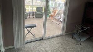 Ein Zimmer mit einer Schiebeglastür, die auf eine Außenpatio führt.