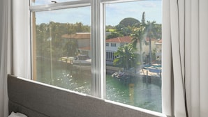 A hotel room with a large window overlooking a marina and buildings. - Bay Harbor Sunset Two Bedrooms Apt (Bay Harbor Islands)