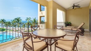 A balcony with a round table and chairs, a ceiling fan, and a view of a beach and pool. - Luxury 3BR Villa for Christmas Week – Relax & Unwind in Nayarit! (Nuevo Nayarit)