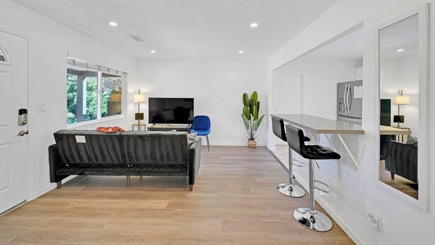 Ein modernes Wohnzimmer mit Sofa, Fernseher und Barbereich.