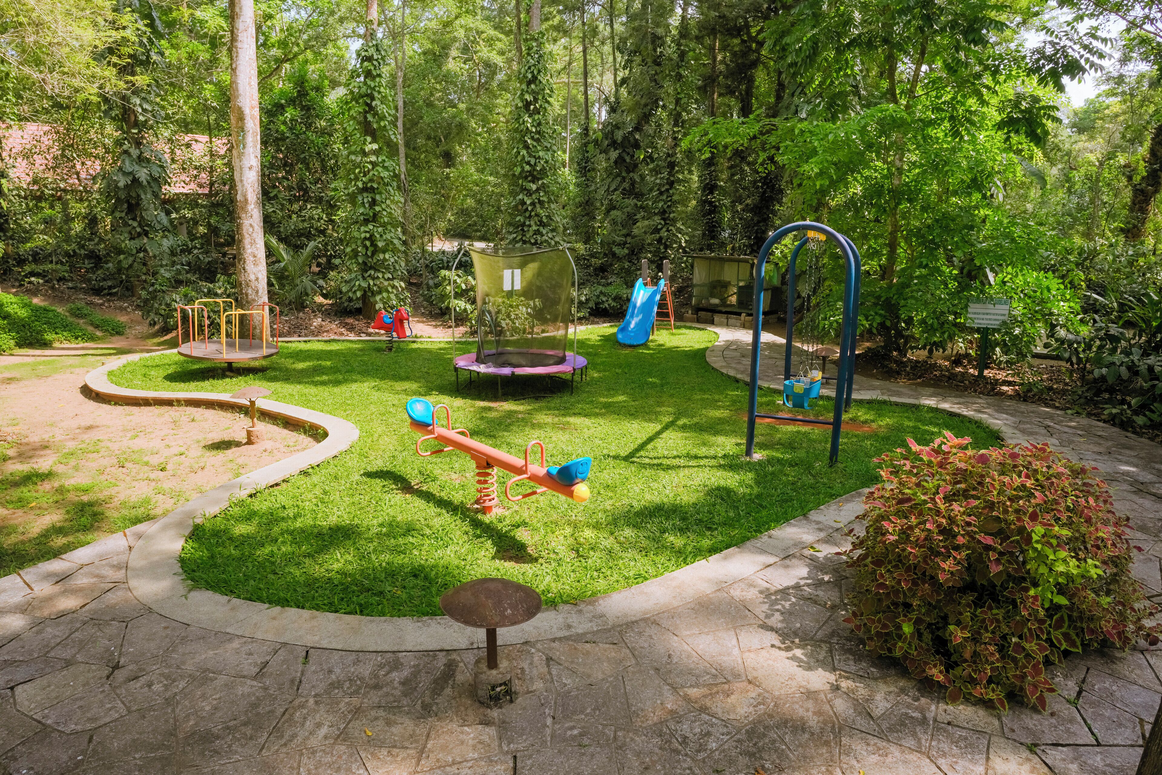 A playground with various play equipment including swings, a slide, and a seesaw.