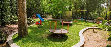 A playground with a slide, swings, and a circular play area.
