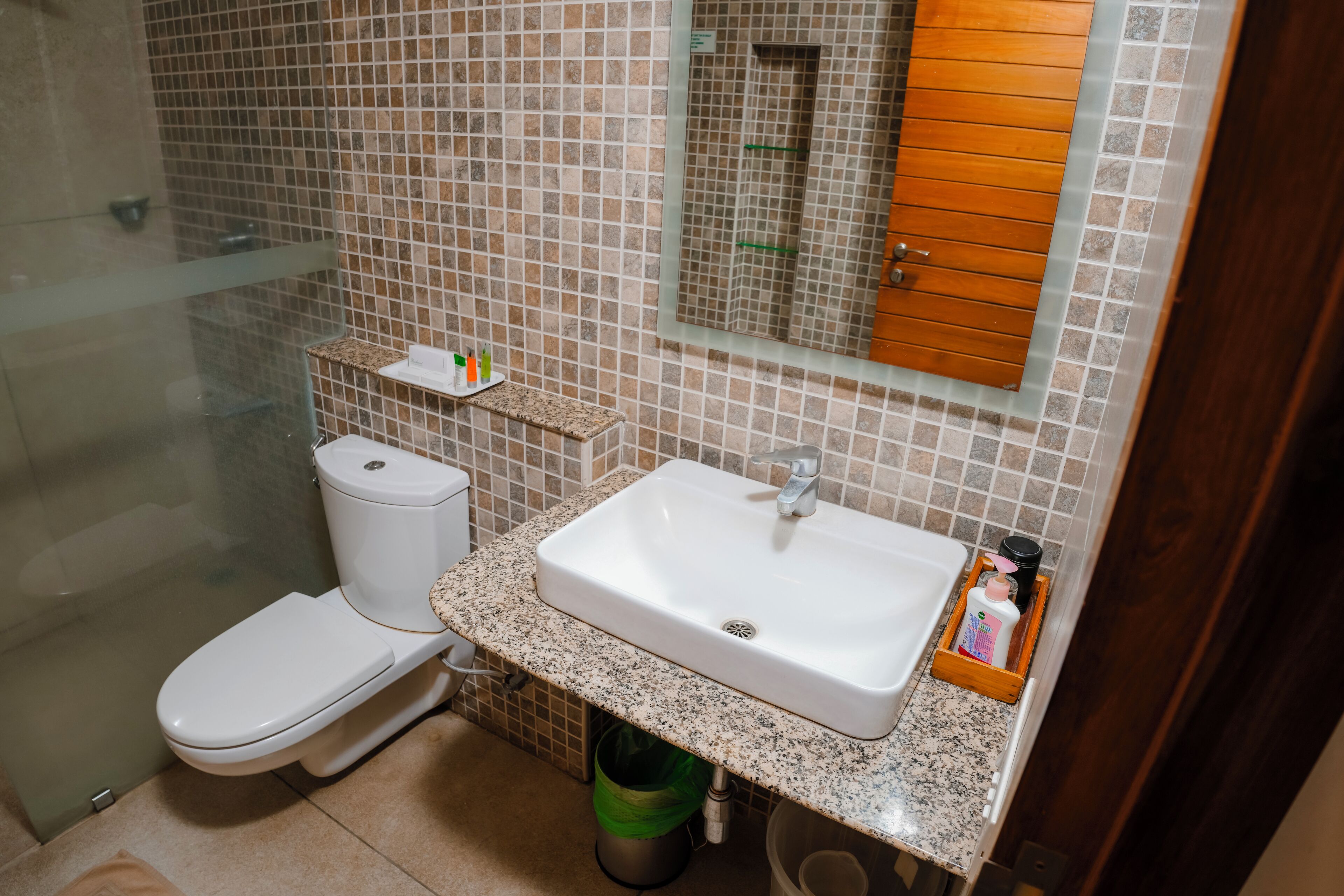 Une salle de bain avec des toilettes, un lavabo et une douche.