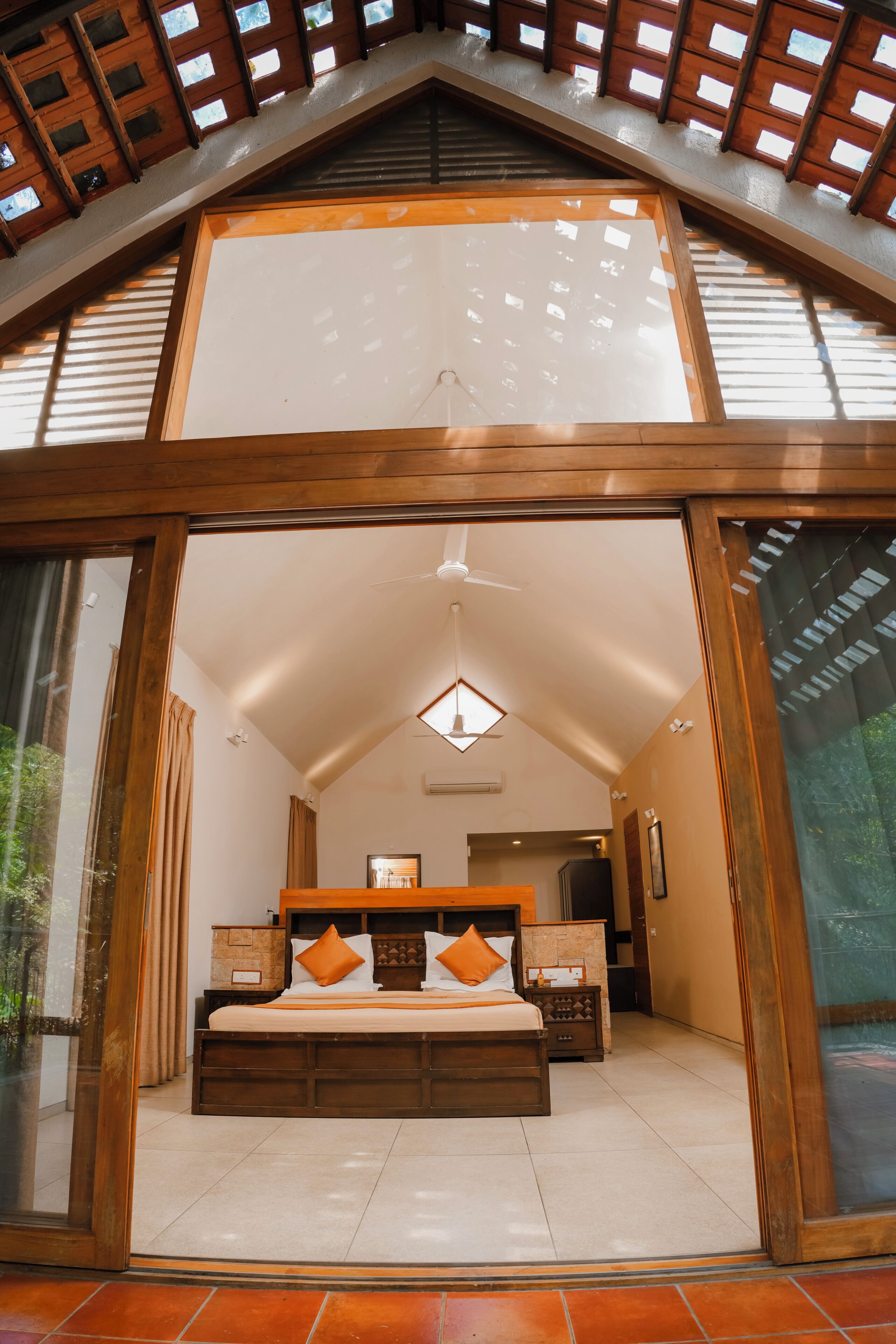 A bedroom with a large bed, wooden headboard, and a skylight.