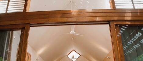 A bedroom with a large bed, wooden headboard, and a skylight.