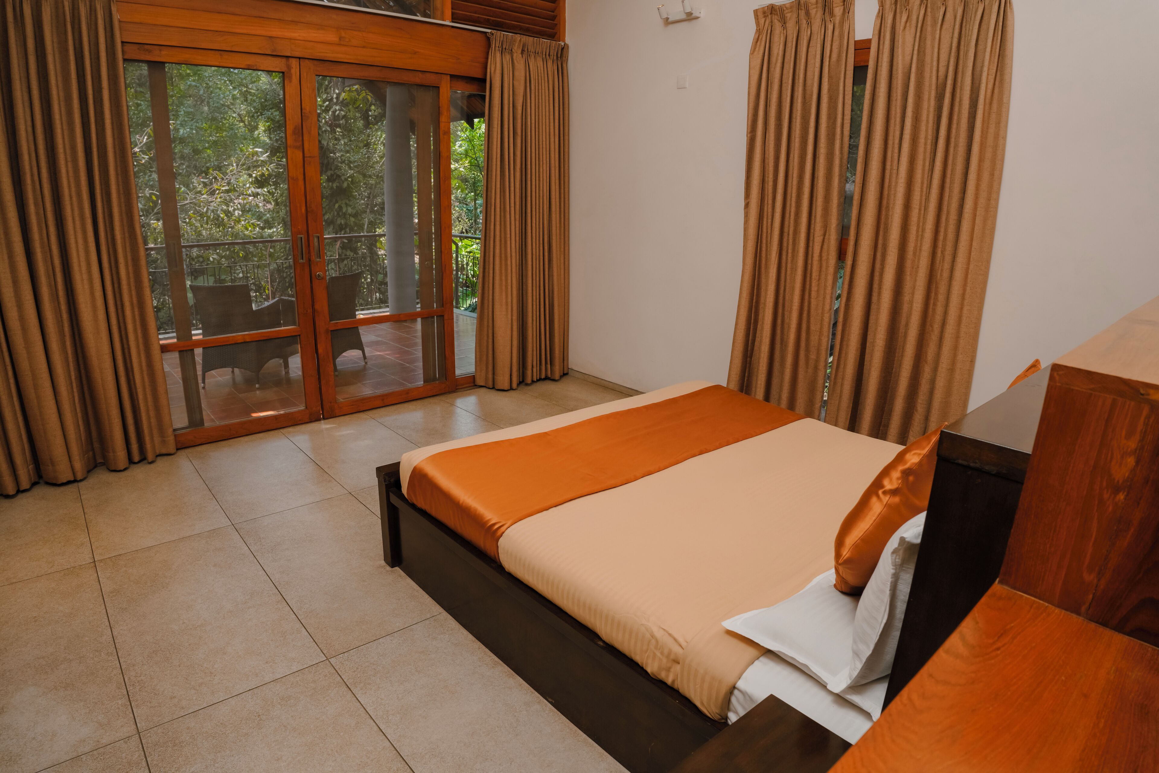 A bedroom with a large bed, sliding glass doors to an outdoor area, and a wooden headboard.