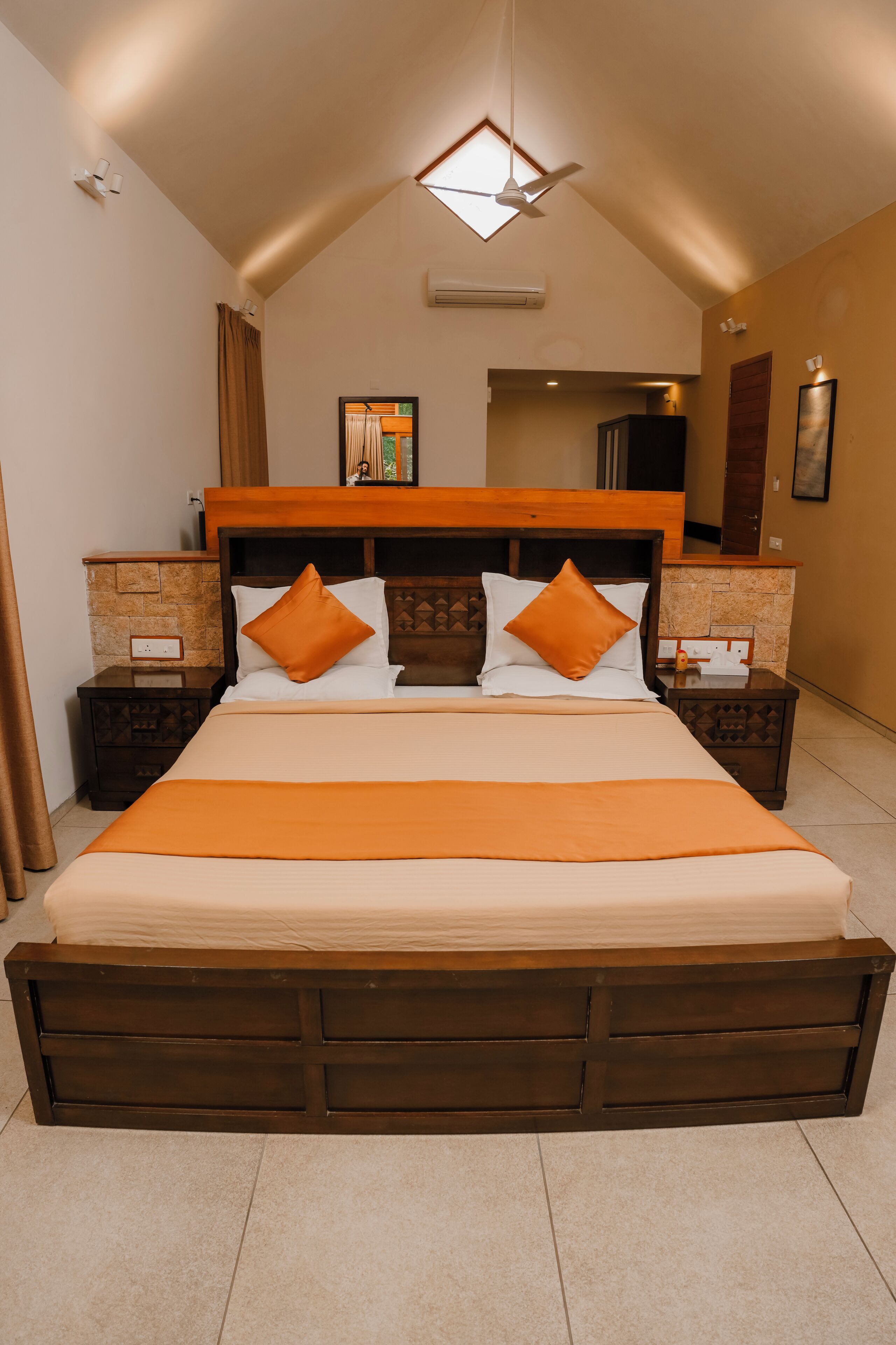 A spacious bedroom with a large bed, wooden headboard, and two nightstands.