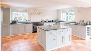 A spacious kitchen with grey cabinets, a central island, and a stove.