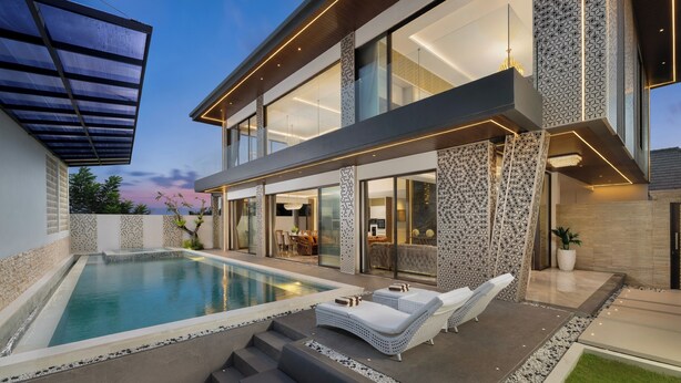 A modern house with a swimming pool, outdoor seating, and a large glass door leading to the interior.