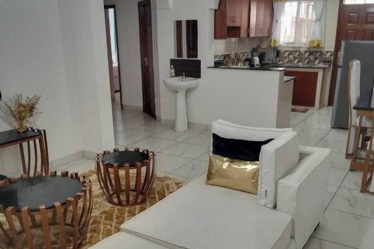 Una sala moderna con un conjunto de sofá, una mesa de centro y un comedor con sillas.