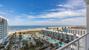 A hotel with multiple swimming pools, a beach view, and a clear sky. - 3rd Coast Getaways - Sapphire 803 (South Padre Island)