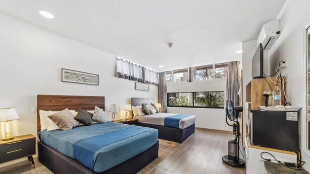 A modern hotel room with two beds, a desk, and a large window with curtains. - Hotel Boutique Emma  (Mexico City)