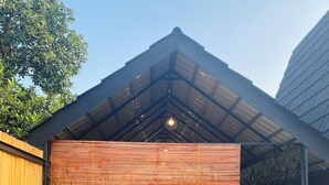 A modern building with a hexagonal tile floor and a wooden fence. - Omah Abiza (Depok)
