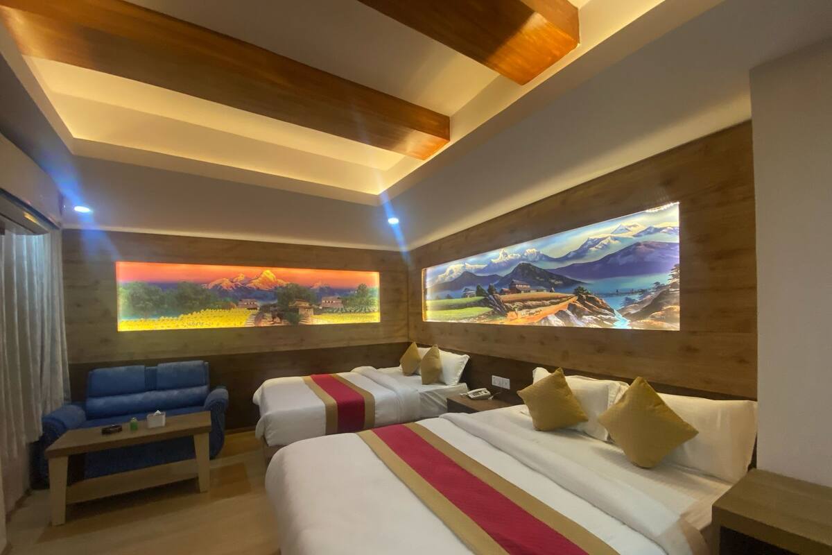 A hotel room with two beds, a sofa, and a large painting on the wall.