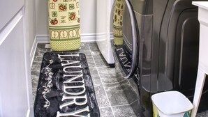 A laundry room with a washing machine, dryer, and a towel rack with a floral-patterned towel. - Spacious and Cozy Room with Private Bathroom in a house with WiFi, AC in Ottawa. (Ottawa)
