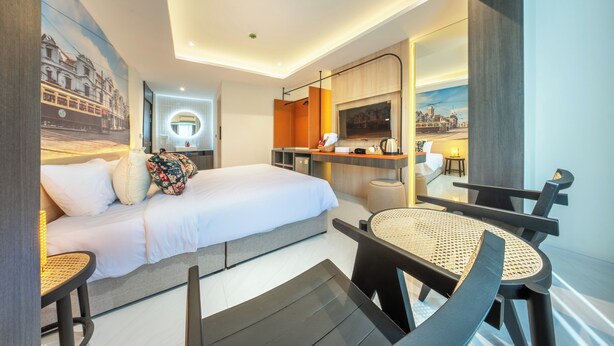 A modern hotel room with a bed, a dining table, and a kitchen area. - U Tor Yaowarat (Bangkok)