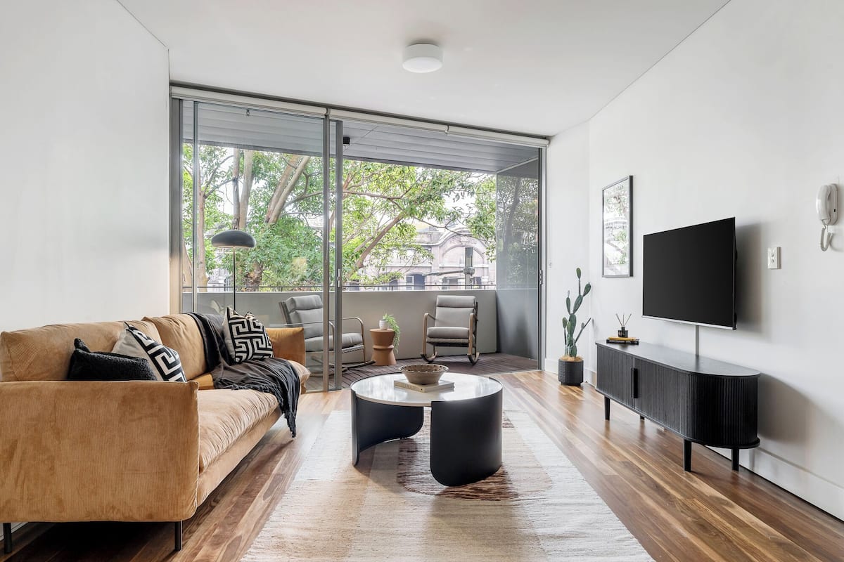 Un salon moderne avec un canapé, une table basse et un téléviseur.