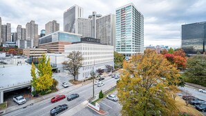 A modern building with a sign reading "CRISTO REY" and a parking lot with several cars. - Downtown Atlanta Condo with City Views (Atlanta)