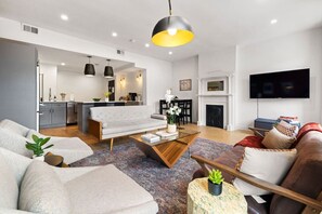Una sala de estar moderna con un sofá, una mesa de centro y un televisor.