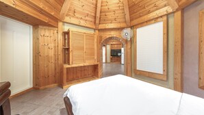 A wooden cabin interior with a bed, a TV, and a fan. - Gapyeong Lulu Kids Pension (Gapyeong)