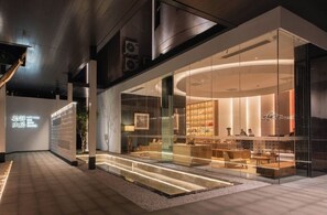 A modern hotel interior with a glass facade, a reception area, and a well-lit interior. - SHIJING HOTEL (Guangzhou)