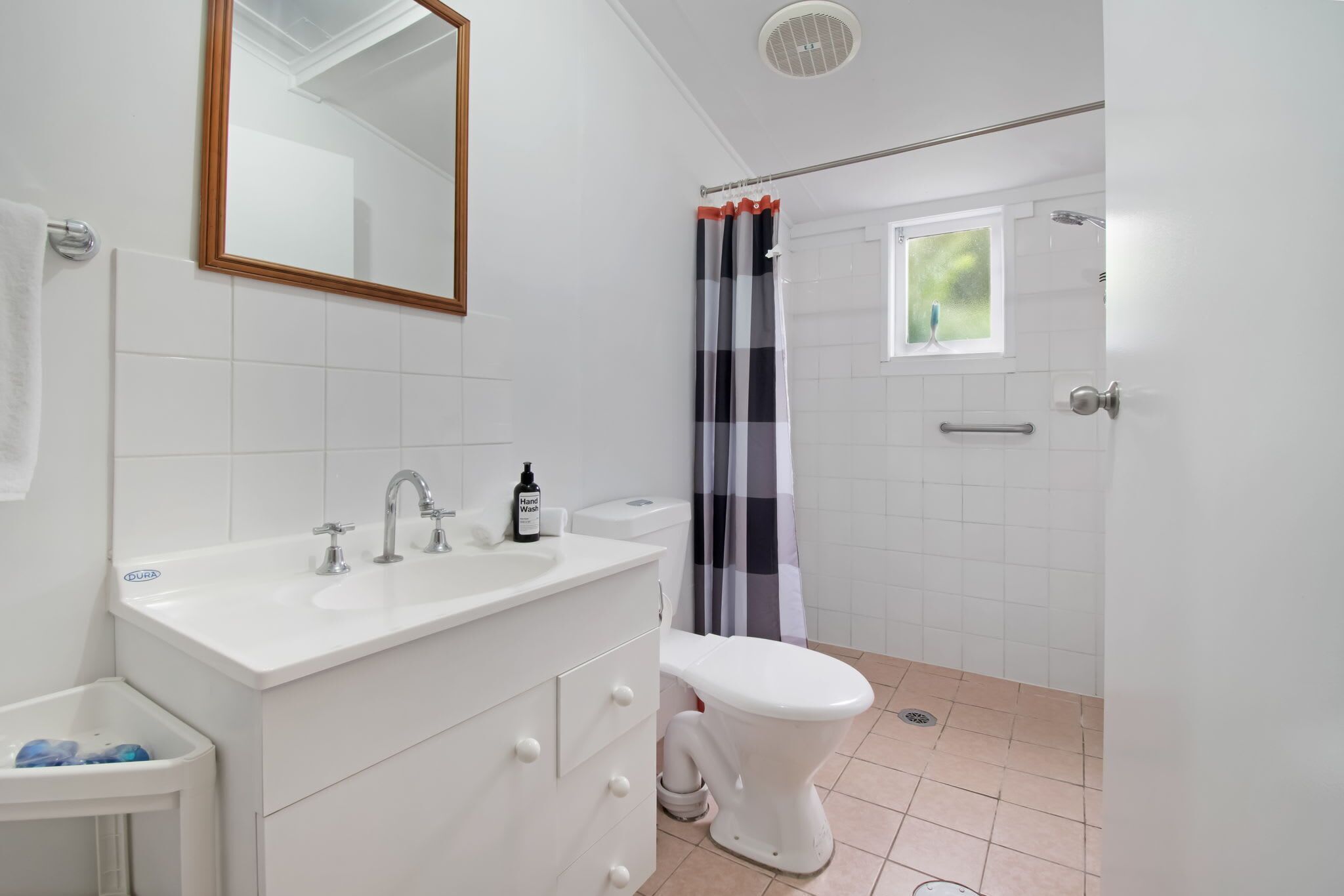 Une salle de bain avec un lavabo blanc, un miroir et des toilettes.