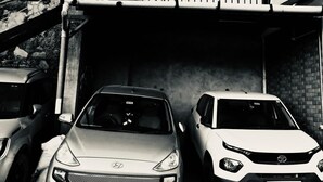 Un parcheggio sotterraneo con tre auto parcheggiate in fila.