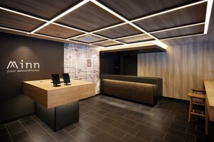 A modern reception area with a wooden desk, a map on the wall, and a seating area with a wooden bench.