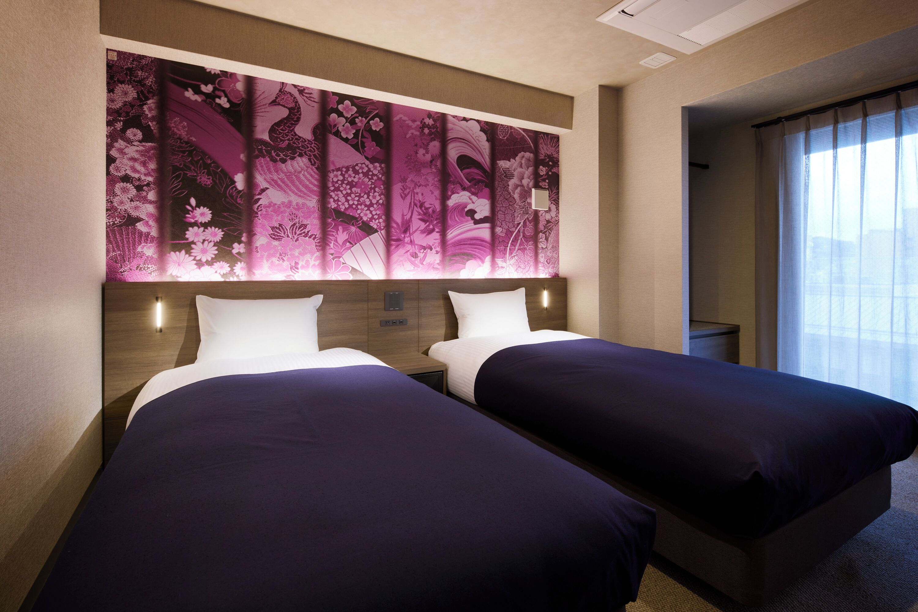 A hotel room with two beds, a large decorative wall panel, and a window with curtains.