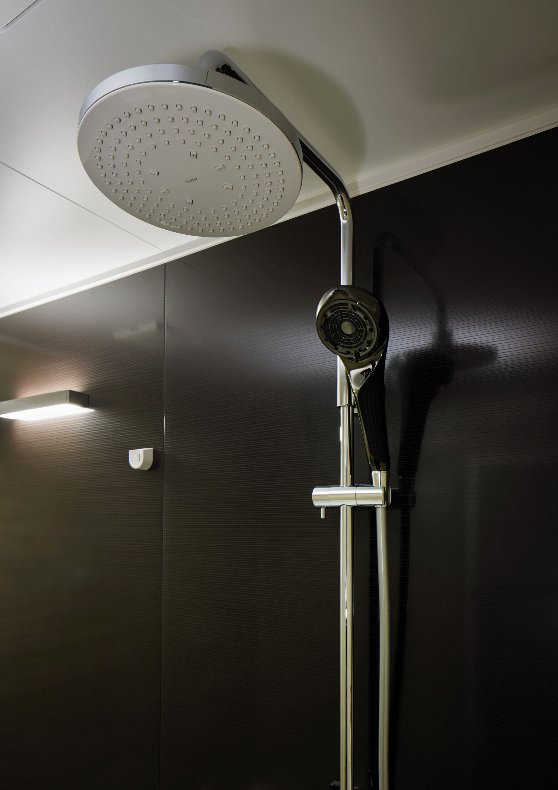A modern showerhead with a circular design and a handheld attachment.