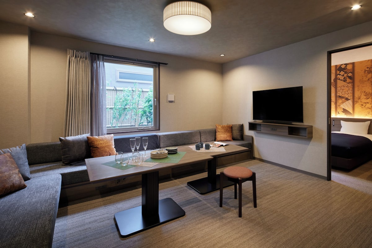 Een moderne woonkamer met een bank, een eettafel en een televisie.