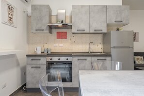 Réfrigérateur, un four, surface de cuisson, vaisselle et ustensiles