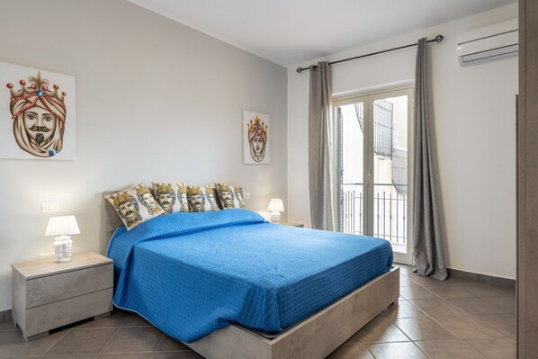 Un dormitorio con cama, mesitas de noche y obras de arte en las paredes.