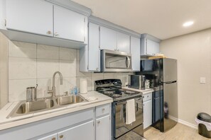 A kitchen with light blue cabinets, stainless steel appliances, and a tiled backsplash. - Private Yard: Pet-Friendly Studio in New Boston! (New Boston)
