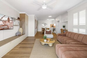 A modern living room with a sofa, coffee table, and artwork on the wall. - Bright 2-Bed Apartment with Stunning Ocean Views (Kings Beach)