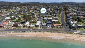Vue aérienne d’un quartier résidentiel avec des maisons, des routes et une plage.