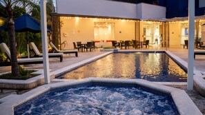 A heated outdoor pool with lounge chairs and a restaurant area. - Comfort Inn Tegucigalpa (Tegucigalpa)