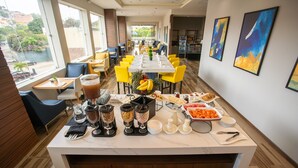 A breakfast buffet setup with various food items and beverages.