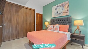 A bedroom with a large bed, two bedside tables with lamps, a wooden wardrobe, and a painting on the wall. - Vista Bucerias 402B - Rooftop Pool & Stunning Views (Bucerías)