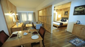 A hotel room with a dining area, a bed, and a kitchenette. - Hotel Phuntsho Pelri (Thimphu)