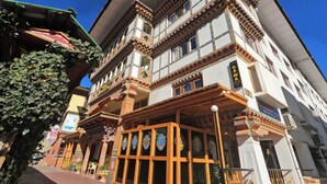 A traditional building with multiple stories, featuring ornate wooden balconies and large windows.