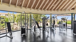 Une salle de sport en plein air équipée de divers appareils d’exercice, dotée d’un espace abrité et offrant une vue sur le paysage environnant.