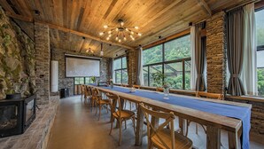 A conference room with a long wooden table, chairs, a projector screen, and large windows with curtains. - Hualu Yuejian Parent Child Homestay (Hangzhou)