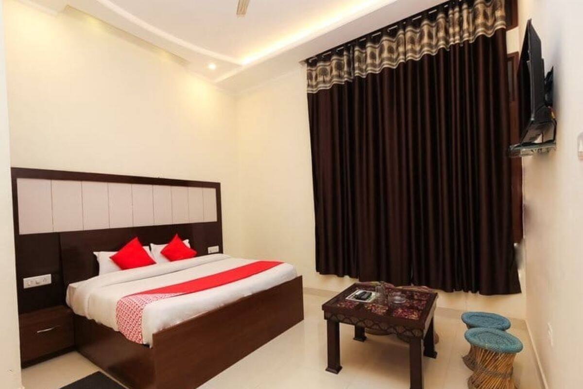 Une chambre d’hôtel moderne avec un grand lit, une petite table et un téléviseur.