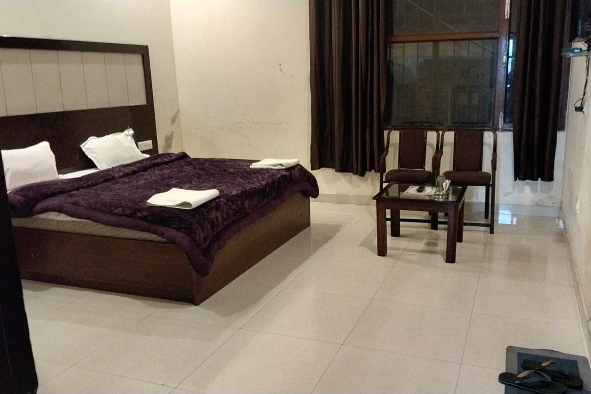 Une chambre d’hôtel avec un lit, une petite table et une chaise.