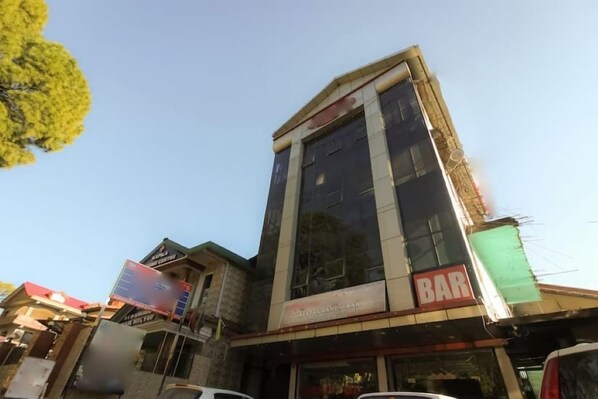 A multi-story building with a restaurant/bar on the ground floor. - Hotel Ambika & Restaurant By GRB (Palampur)