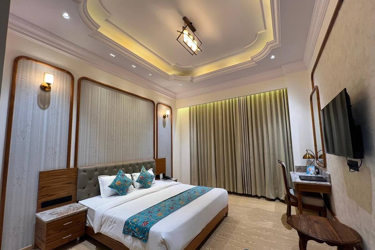 Une chambre d’hôtel bien aménagée, dotée d’un grand lit, d’un bureau et d’une télévision.