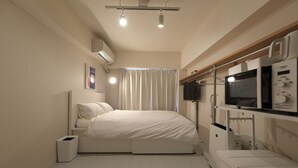 A modern bedroom with a bed, bedside table, and a built-in TV.