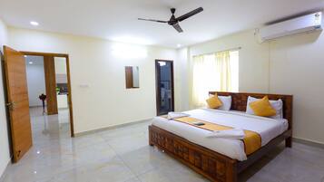 A spacious bedroom with a large bed, a ceiling fan, and an air conditioning unit.