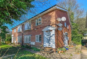 A two-story brick house with satellite dishes, a front door, and a small garden. - 2-Bed in Quiet Area, Easy City & Transport Access (Nottingham)